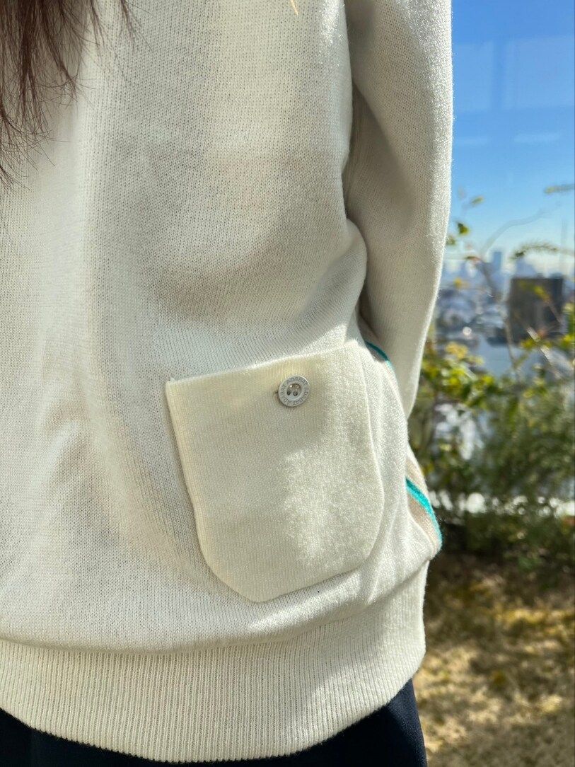 ホワイト系のニット/セーター、ブルー系のスカート、ブルー系のゴルフグッズを着用したレディースの冬コーディネートの5枚目の写真