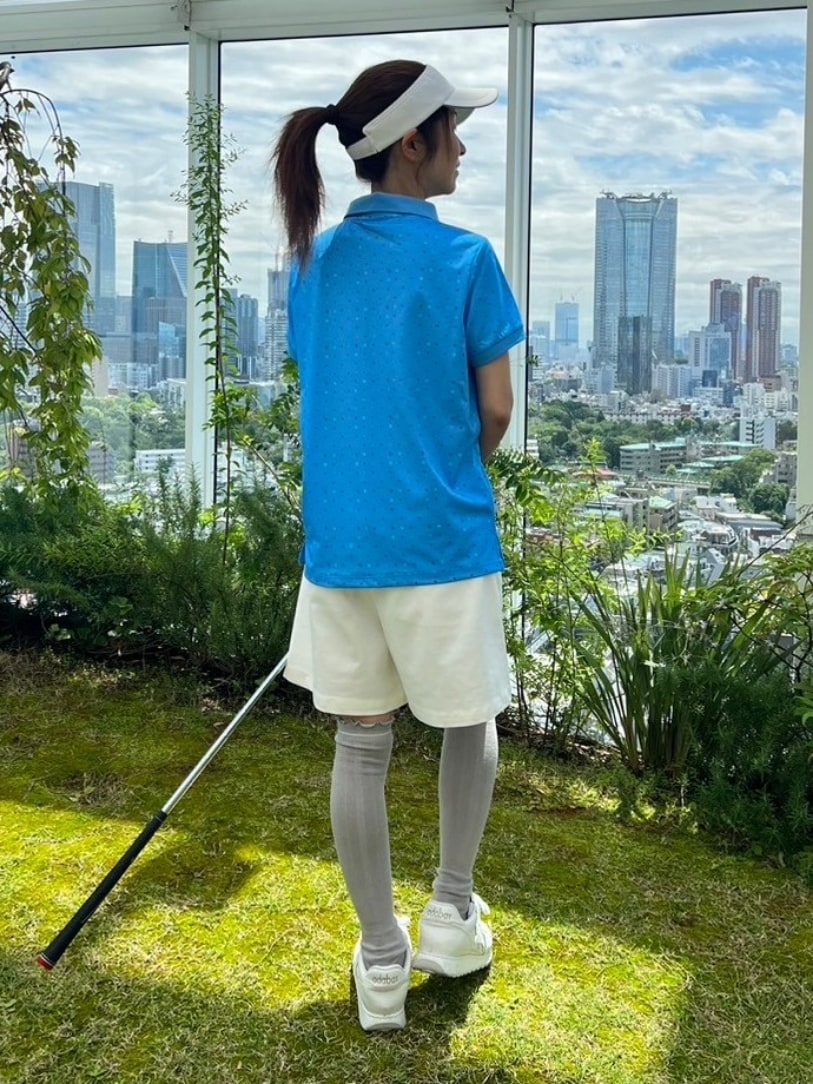 ブルー系のポロシャツ、ホワイト系のその他パンツ、ホワイト系のサンバイザーを着用したレディースの春コーディネートの3枚目の写真