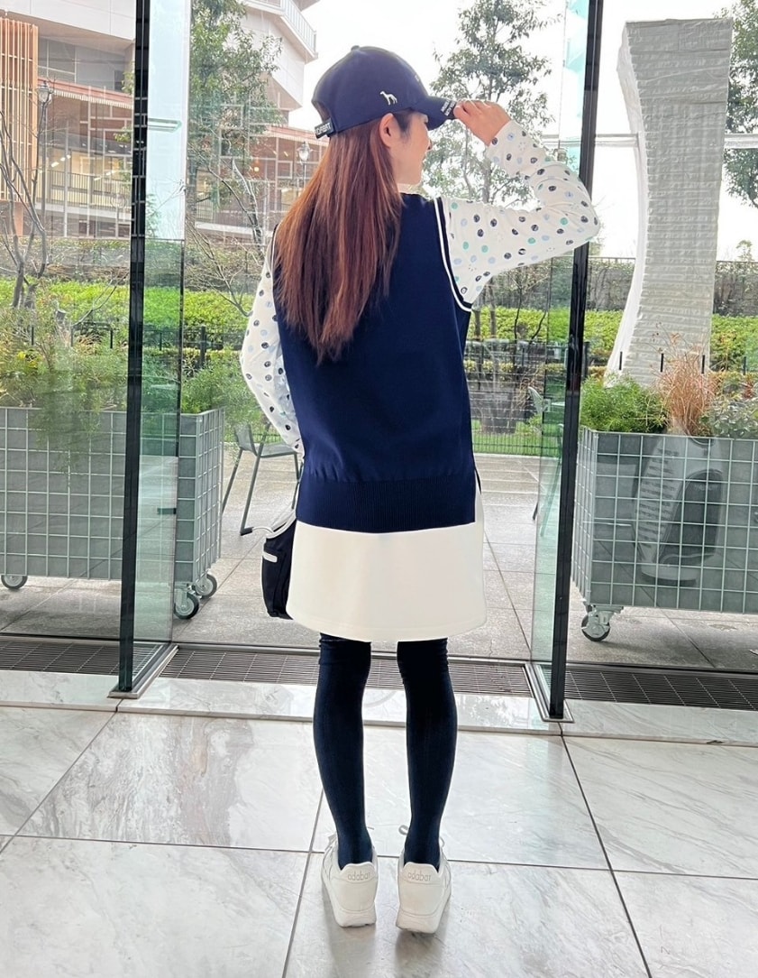 グリーン系のTシャツ/カットソー、ブルー系のベスト、ホワイト系のスカートを着用したレディースの冬コーディネートの3枚目の写真