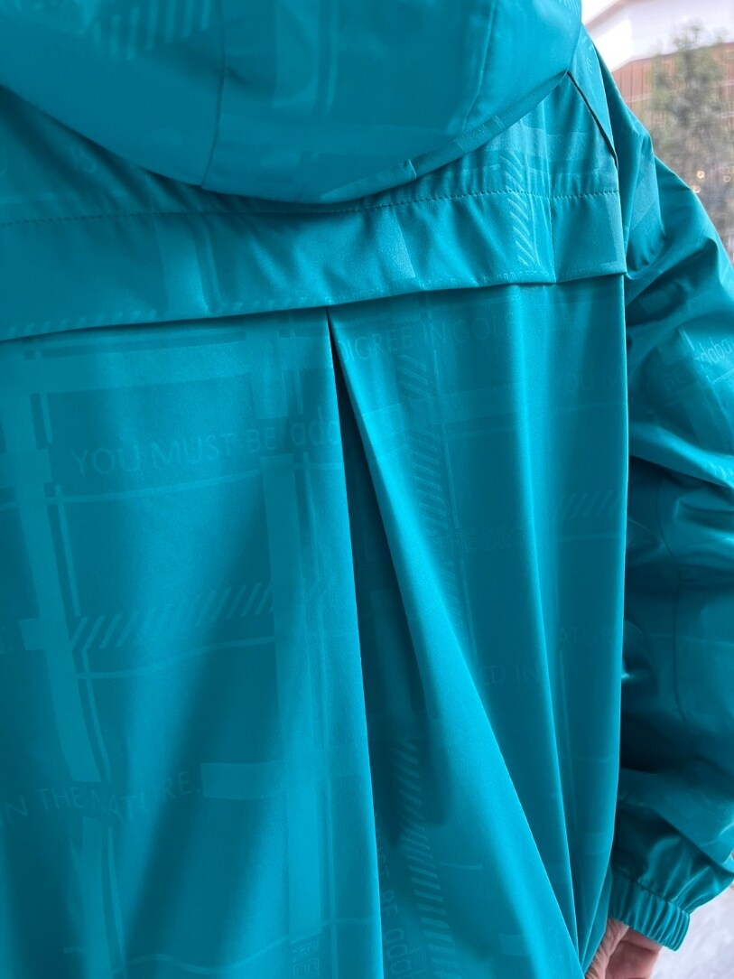 グリーン系のブルゾン、ブルー系のスカート、ブルー系のトートバッグを着用したレディースの春コーディネートの5枚目の写真