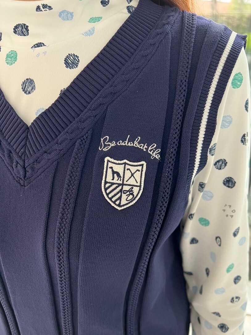 グリーン系のTシャツ/カットソー、ブルー系のベスト、ホワイト系のスカートを着用したレディースの冬コーディネートの4枚目の写真