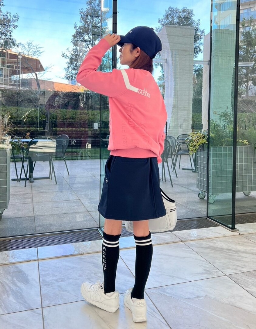 ピンク系のニット/セーター、ブルー系のスカート、ホワイト系のトートバッグを着用したレディースの冬コーディネートの3枚目の写真