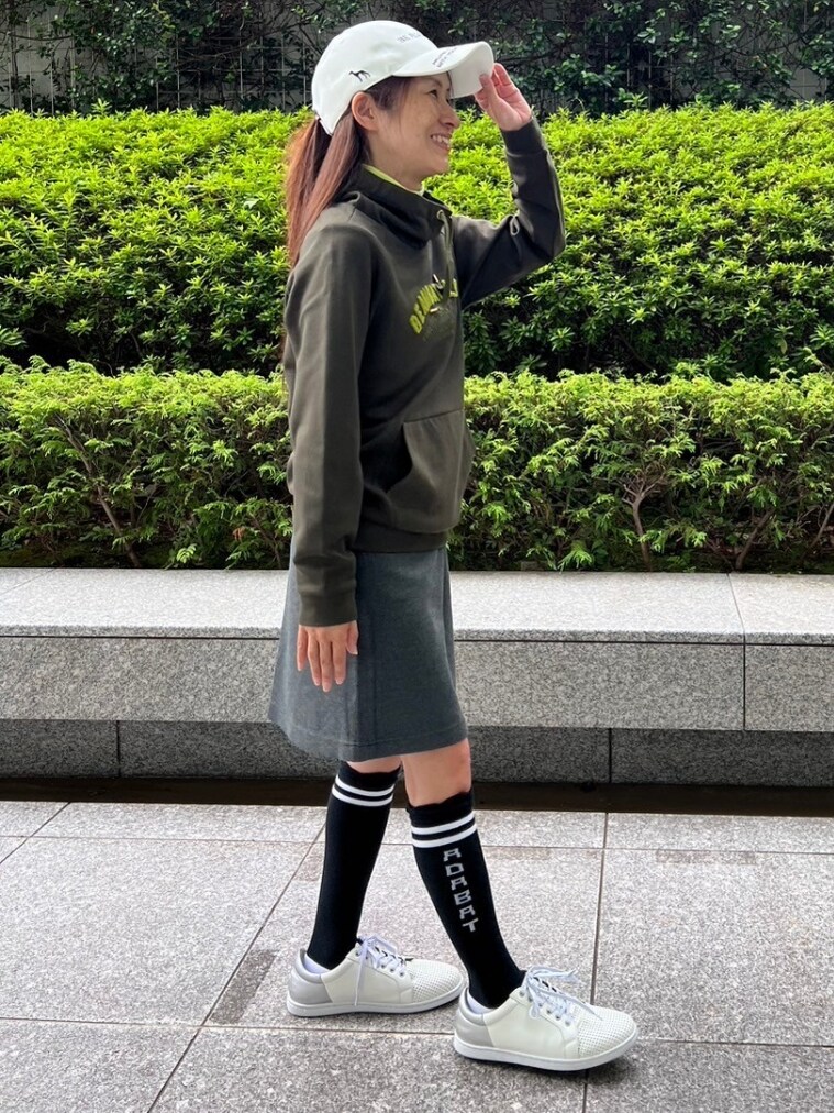 ブルー系のスカート、ホワイト系のキャップを着用したレディースの秋コーディネートの2枚目の写真