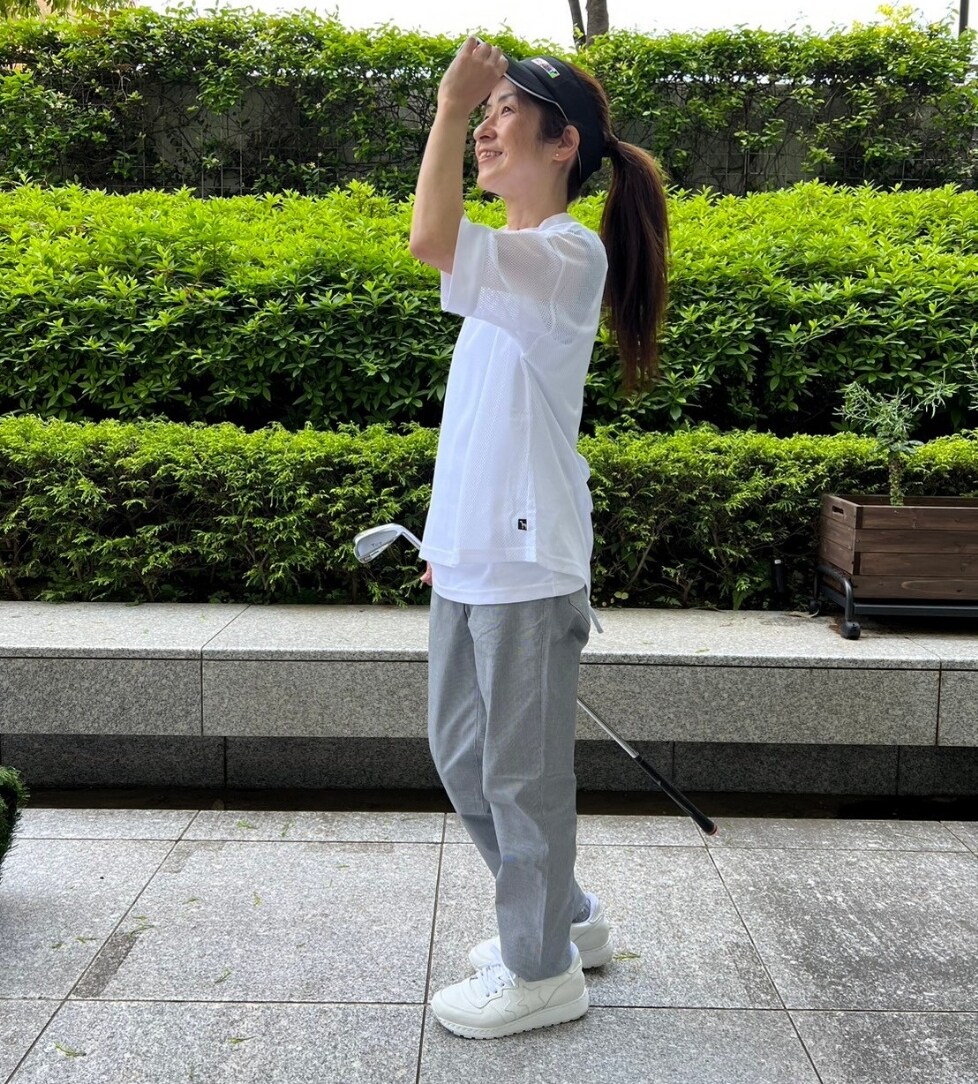 ホワイト系のTシャツ/カットソー、ホワイト系のその他パンツ、ブラック系のサンバイザーを着用したレディースの春コーディネートの2枚目の写真