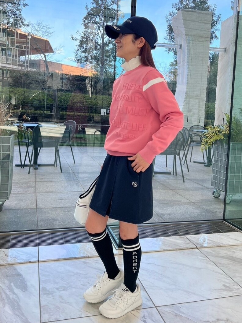 ピンク系のニット/セーター、ブルー系のスカート、ホワイト系のトートバッグを着用したレディースの冬コーディネートの2枚目の写真