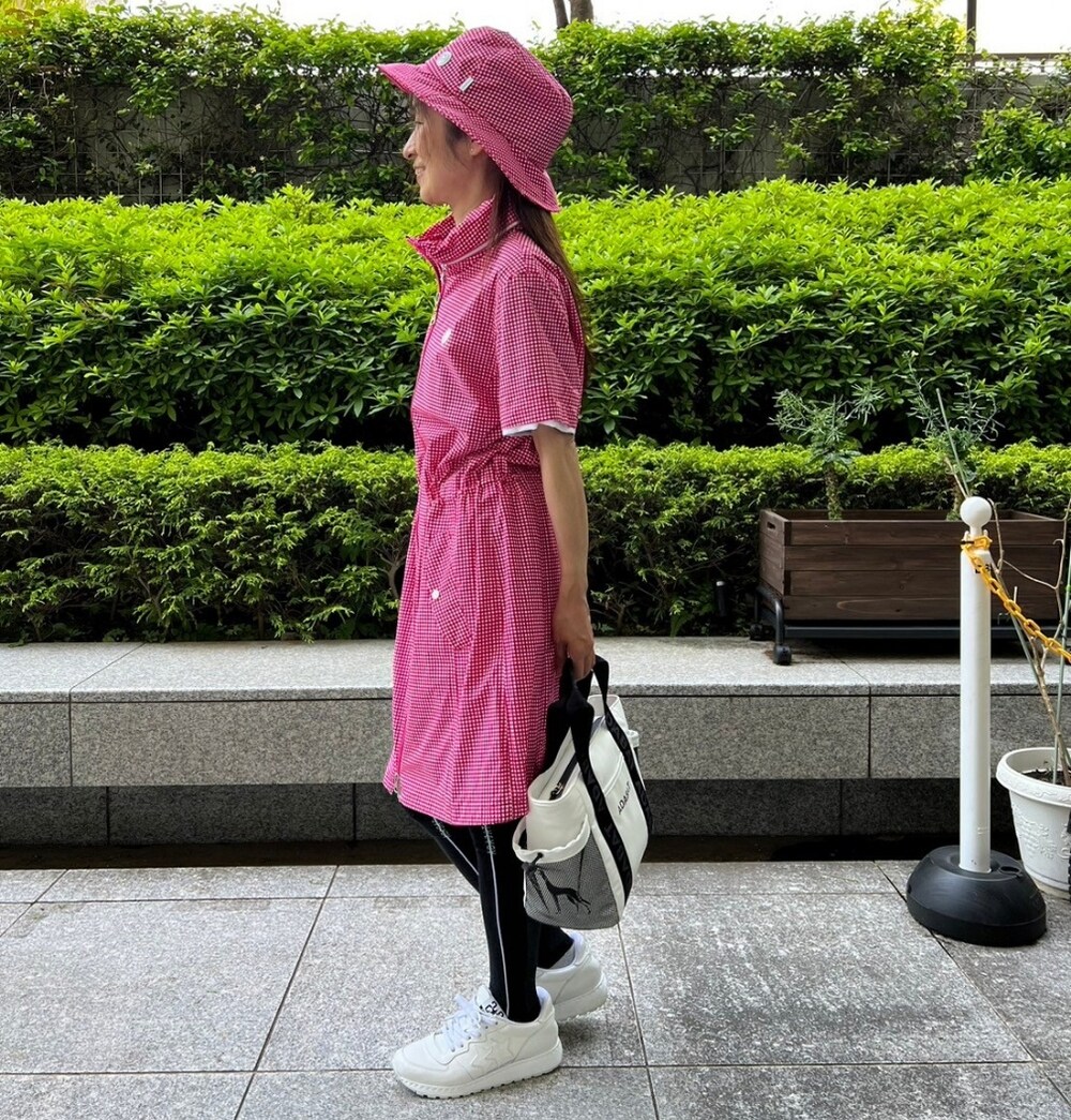 ピンク系のブルゾン、ホワイト系のトートバッグ、ピンク系のハットを着用したレディースの夏コーディネートの2枚目の写真