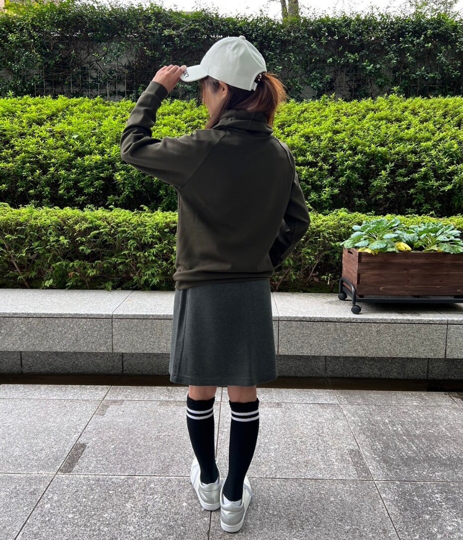 ブルー系のスカート、ホワイト系のキャップを着用したレディースの秋コーディネートの3枚目の写真
