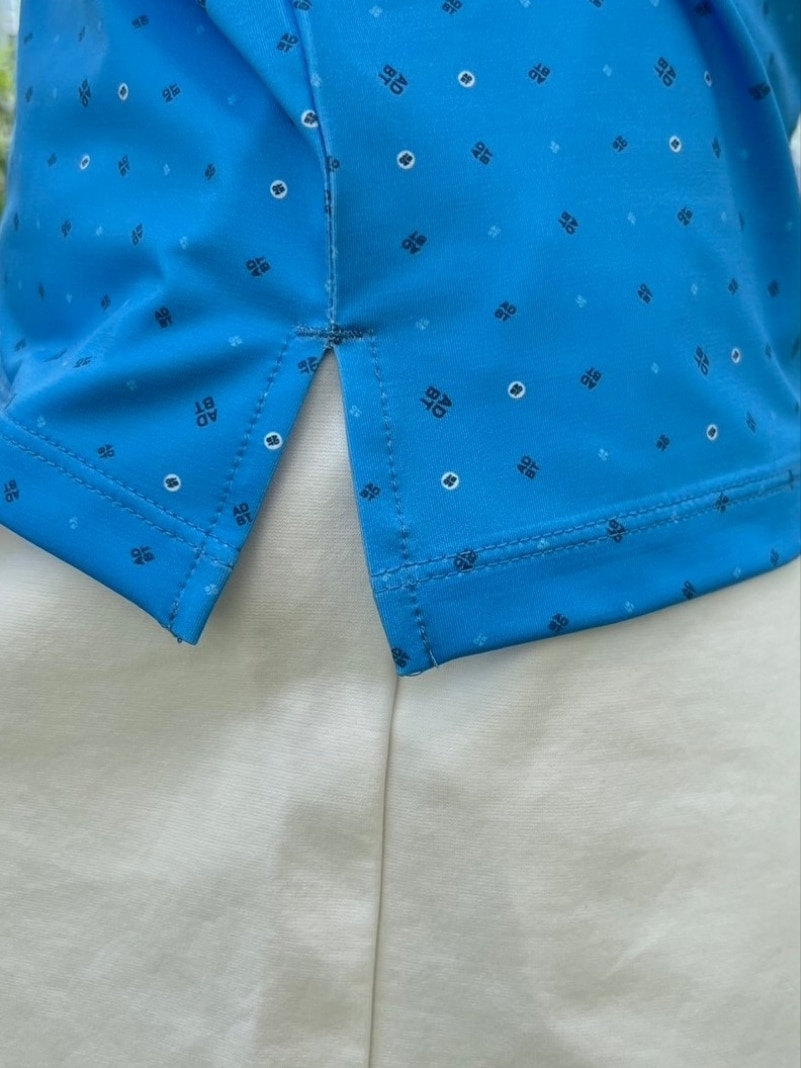 ブルー系のポロシャツ、ホワイト系のその他パンツ、ホワイト系のサンバイザーを着用したレディースの春コーディネートの5枚目の写真