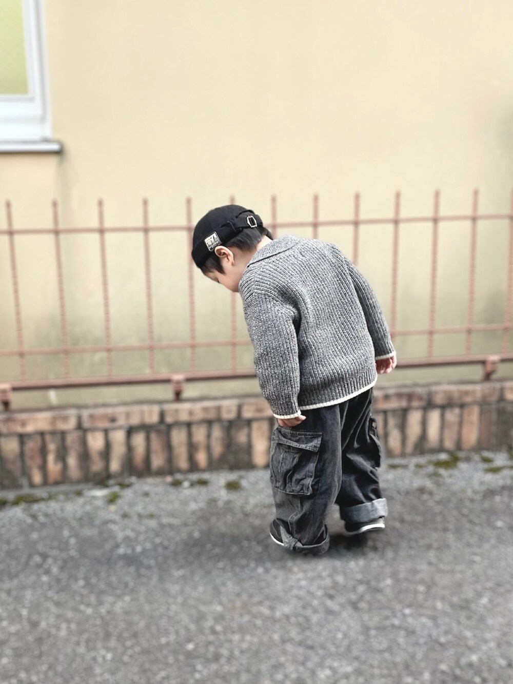 グレー系のニット/セーター、ブラック系のスニーカー、グレー系のデニムパンツを着用したキッズの秋コーディネートの3枚目の写真