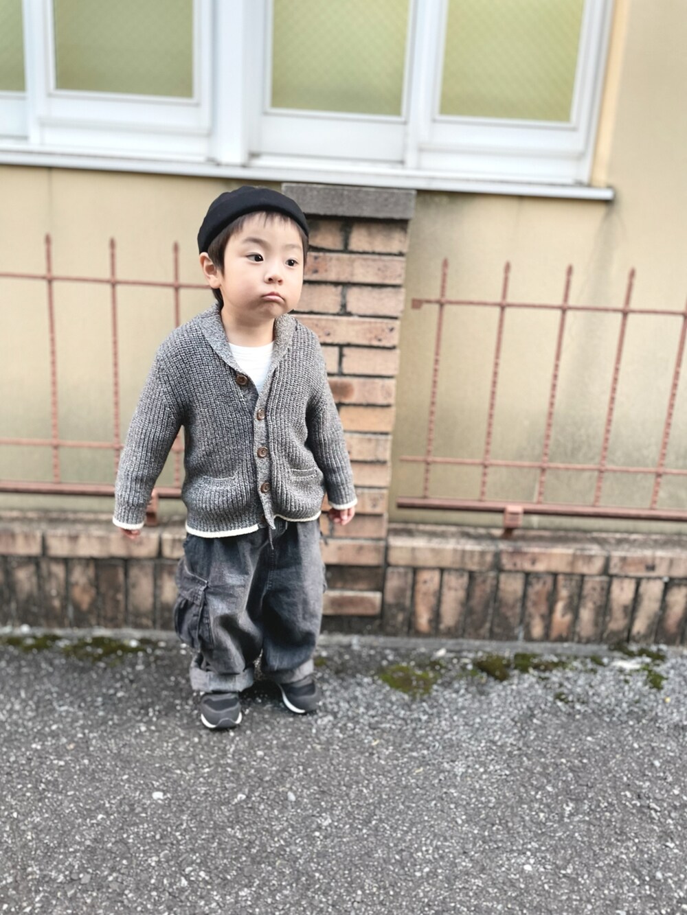 グレー系のニット/セーター、ブラック系のスニーカー、グレー系のデニムパンツを着用したキッズの秋コーディネートの2枚目の写真