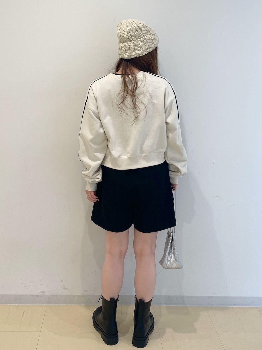 ホワイト系のスウェット、シルバー系のハンドバッグ、ブラック系のその他パンツを着用したレディースの冬コーディネートの2枚目の写真