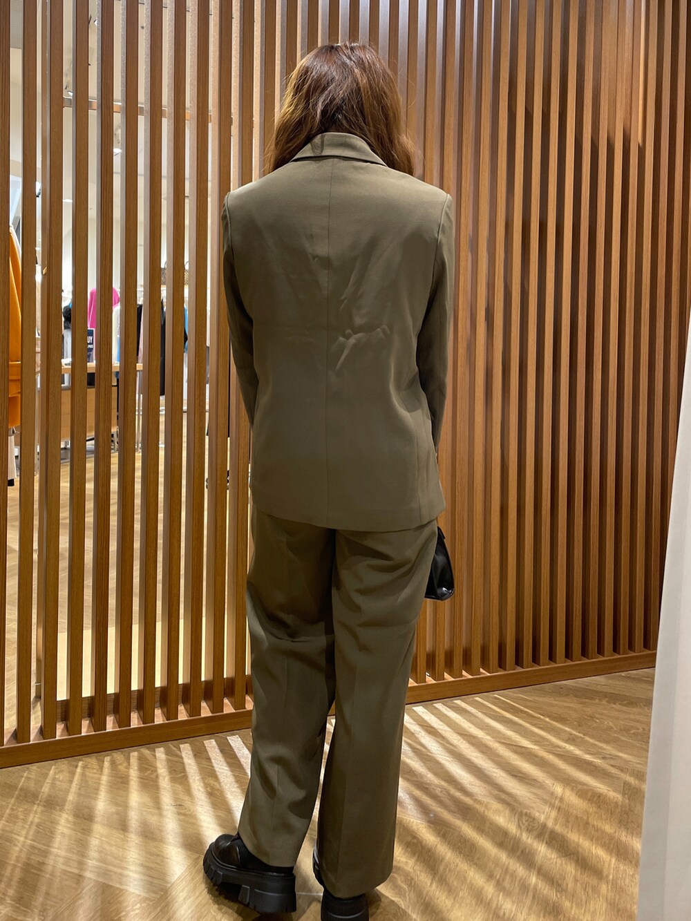 ブラウン系のテーラードジャケット、ベージュ系のTシャツ/カットソー、ブラウン系のスラックスを着用したレディースの秋コーディネートの3枚目の写真