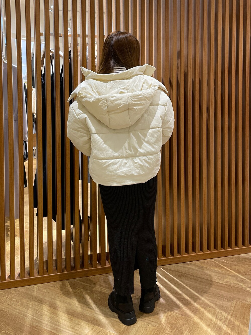 ホワイト系のブルゾン、ホワイト系のニット/セーター、ブラック系のスカートを着用したレディースの冬コーディネートの3枚目の写真