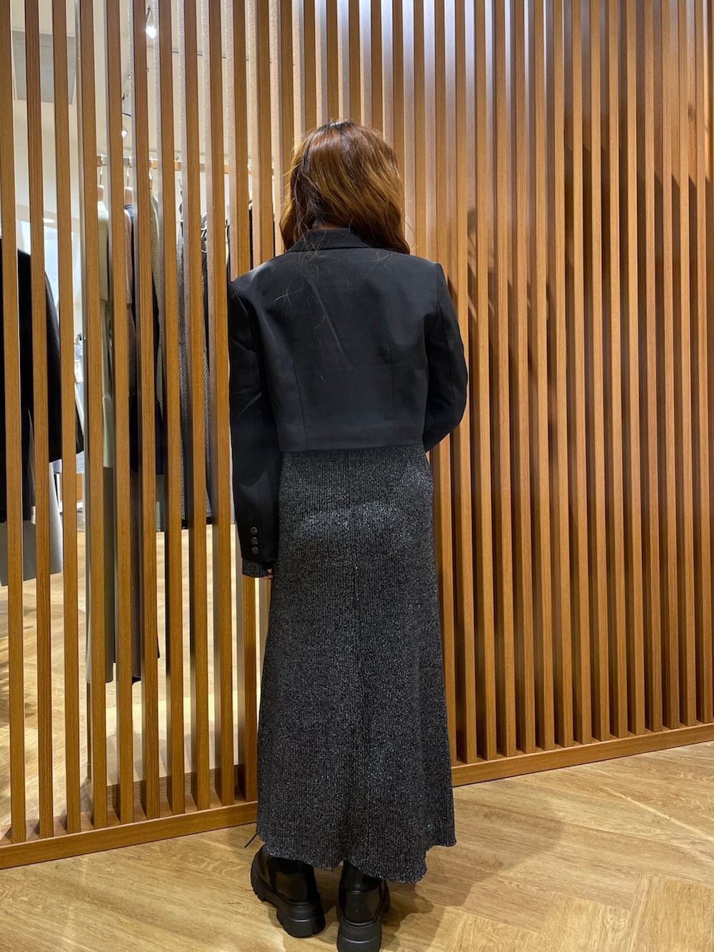 ブラック系のワンピース、ブラック系のテーラードジャケット、ブラック系のブーツを着用したレディースの冬コーディネートの2枚目の写真