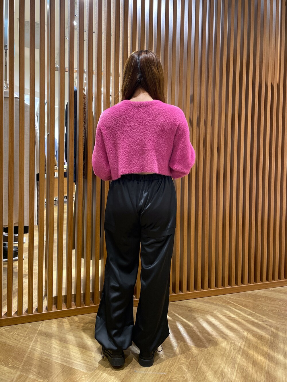 ピンク系のニット/セーター、ブラック系のカーゴパンツ、シルバー系のハンドバッグを着用したレディースの秋コーディネートの2枚目の写真