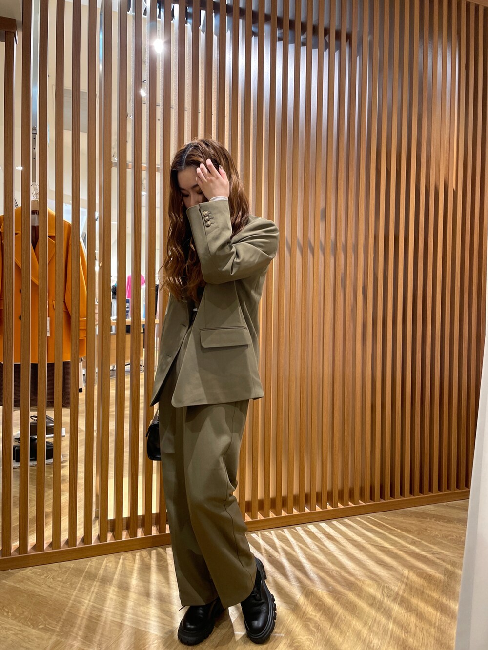 ブラウン系のテーラードジャケット、ベージュ系のTシャツ/カットソー、ブラウン系のスラックスを着用したレディースの秋コーディネートの2枚目の写真