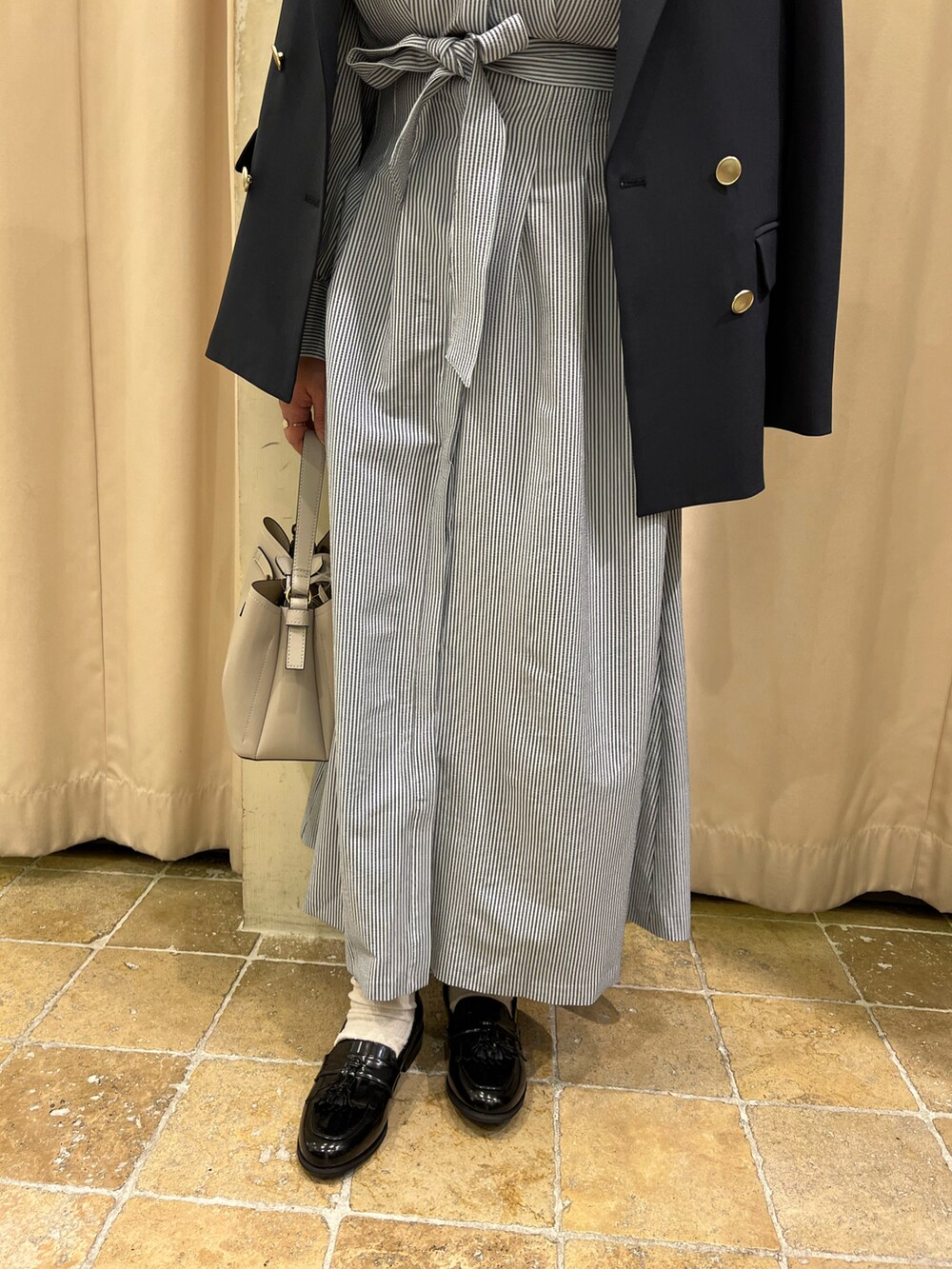 ブルー系のノーカラージャケット、ブルー系のワンピース、ブラック系のローファーを着用したレディースの春コーディネートの3枚目の写真