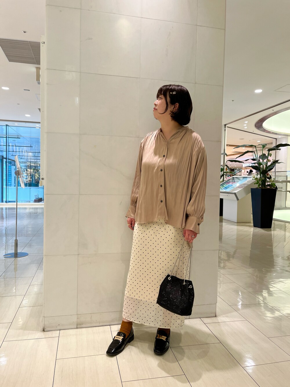 ベージュ系のシャツ/ブラウス、ベージュ系のスカート、ブラック系のローファーを着用したレディースの春コーディネートの2枚目の写真