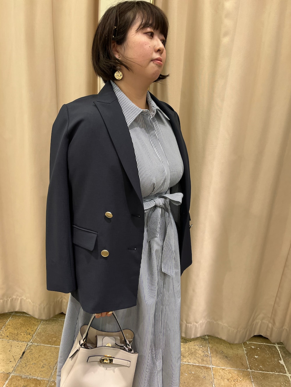 ブルー系のノーカラージャケット、ブルー系のワンピース、ブラック系のローファーを着用したレディースの春コーディネートの2枚目の写真