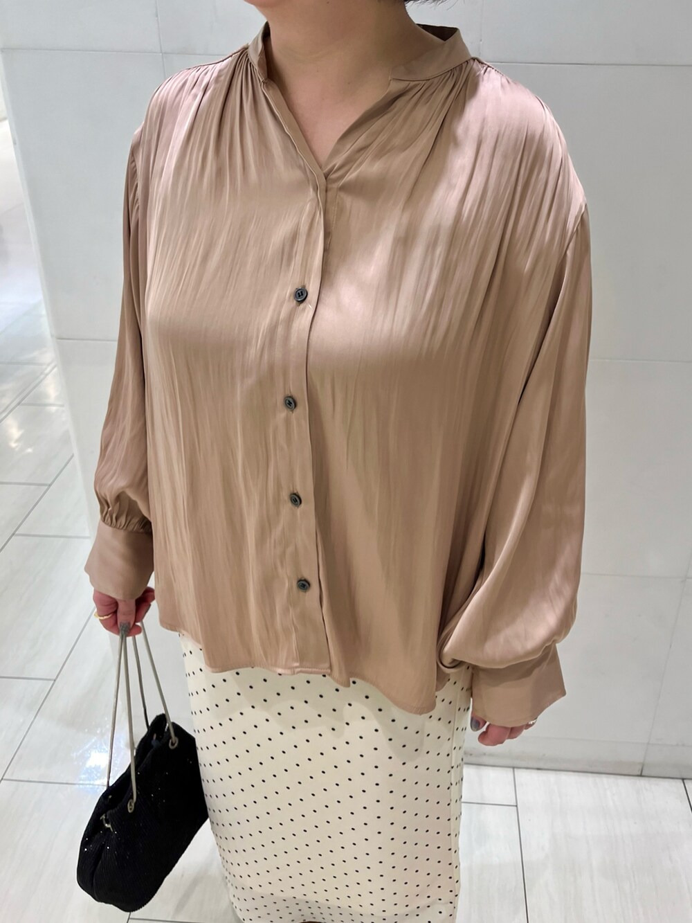 ベージュ系のシャツ/ブラウス、ベージュ系のスカート、ブラック系のローファーを着用したレディースの春コーディネートの3枚目の写真