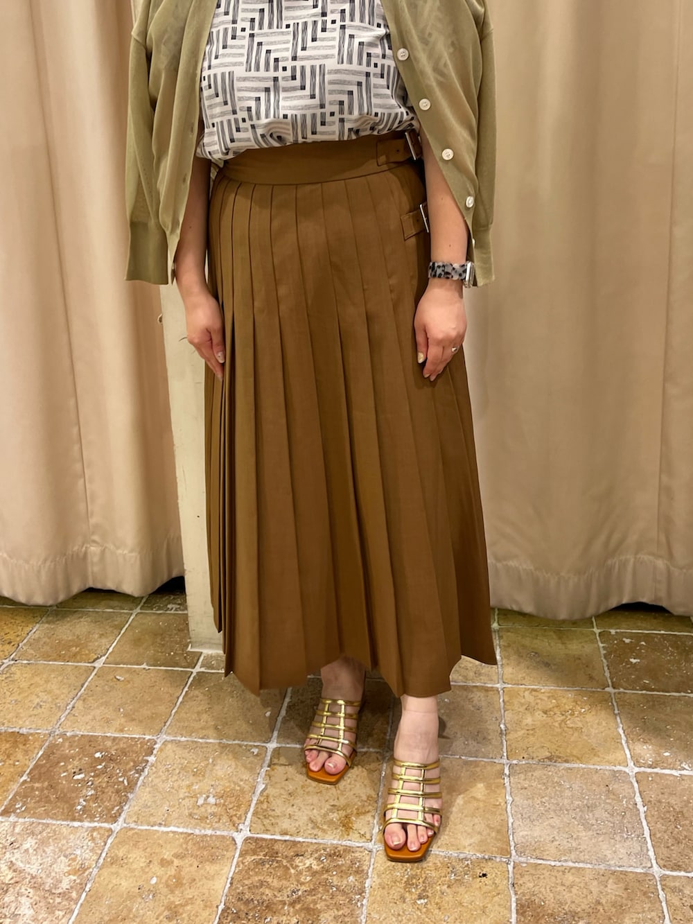 グリーン系のカーディガン/ボレロ、ホワイト系のシャツ/ブラウス、ブラウン系のスカートを着用したレディースの夏コーディネートの3枚目の写真