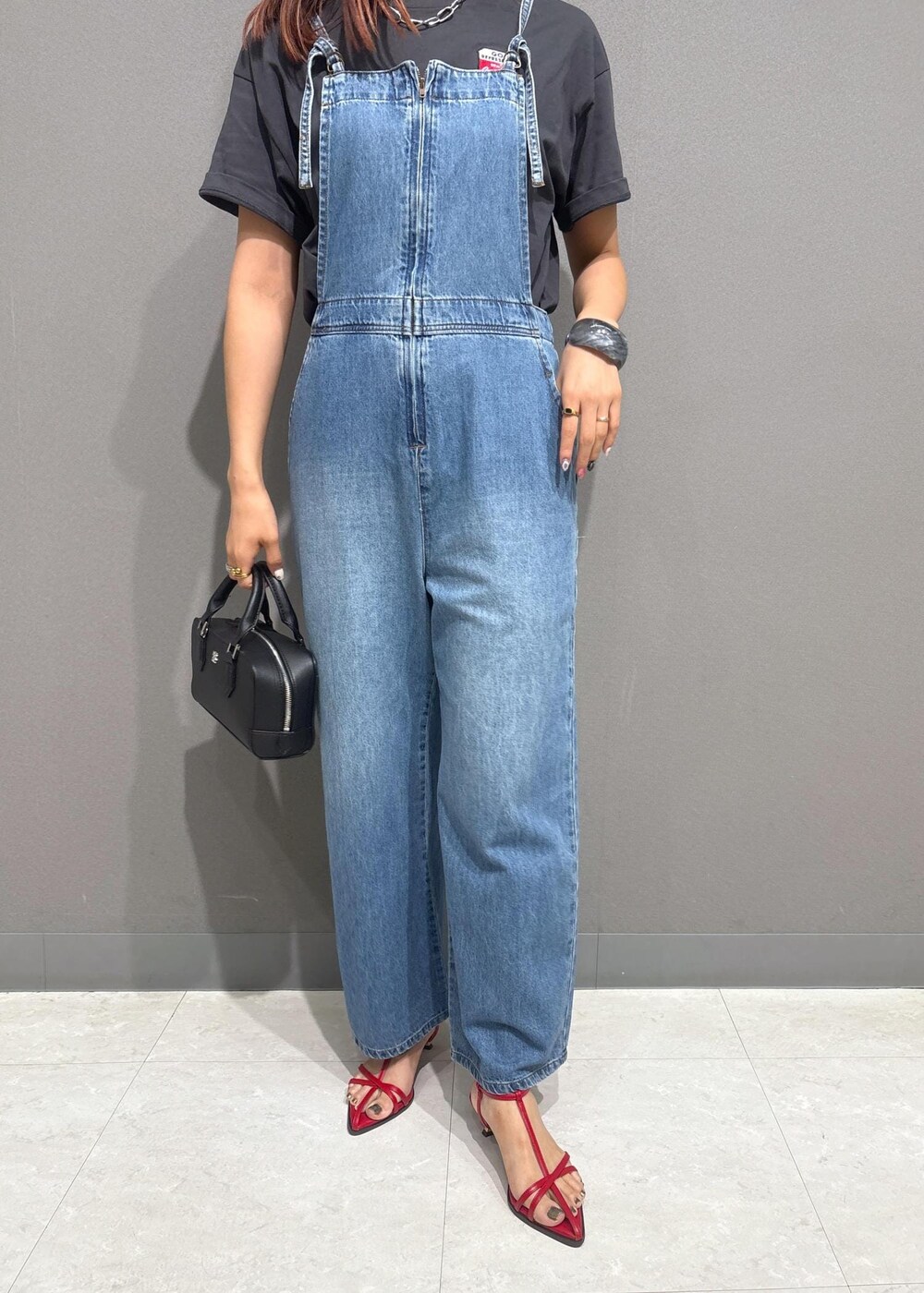 レッド系のサンダル、ブラック系のショルダーバッグ、グレー系のTシャツ/カットソーを着用したレディースの夏コーディネートの7枚目の写真