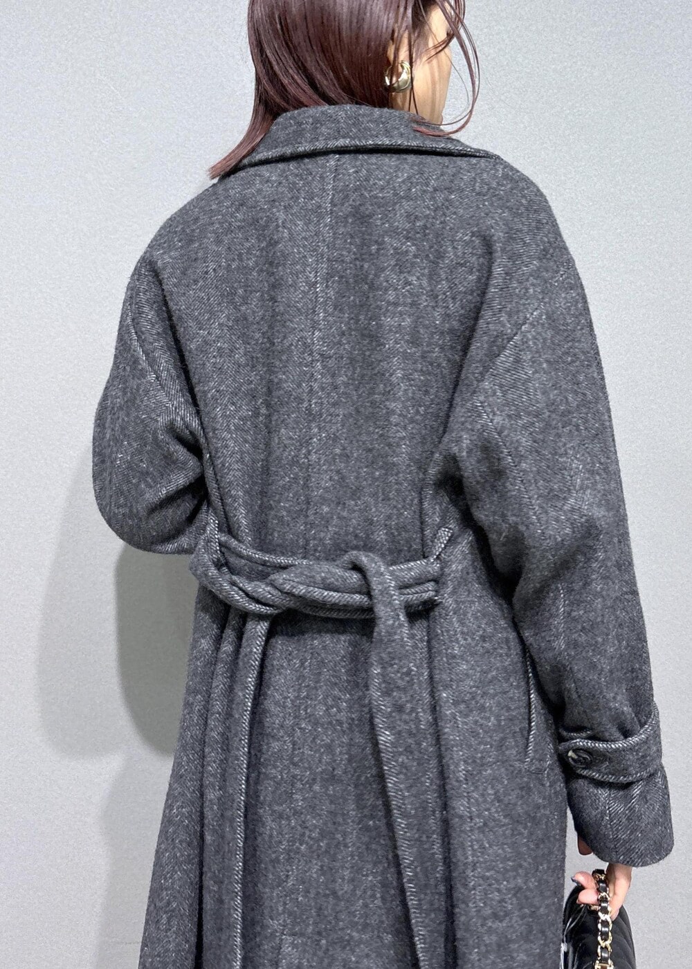 ブラウン系のスラックス、ブラウン系のブーツ、グレー系のその他アウターを着用したレディースの冬コーディネートの9枚目の写真