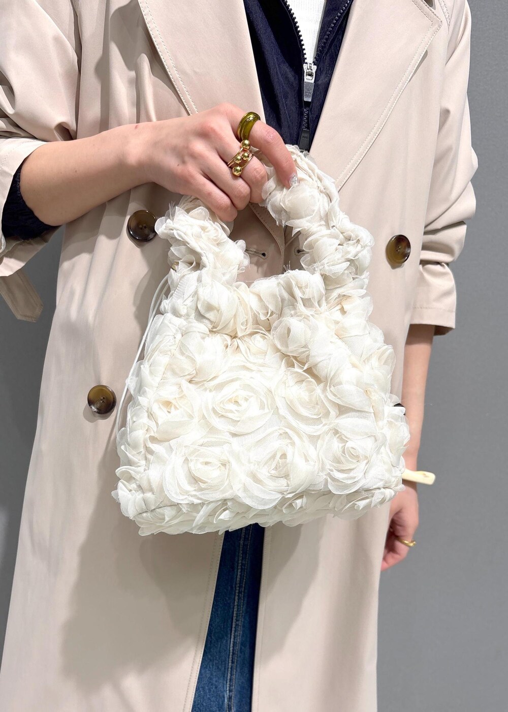 ブルー系のデニムスカート、ブルー系のブルゾン、ベージュ系のトレンチコートを着用したレディースの春コーディネートの9枚目の写真