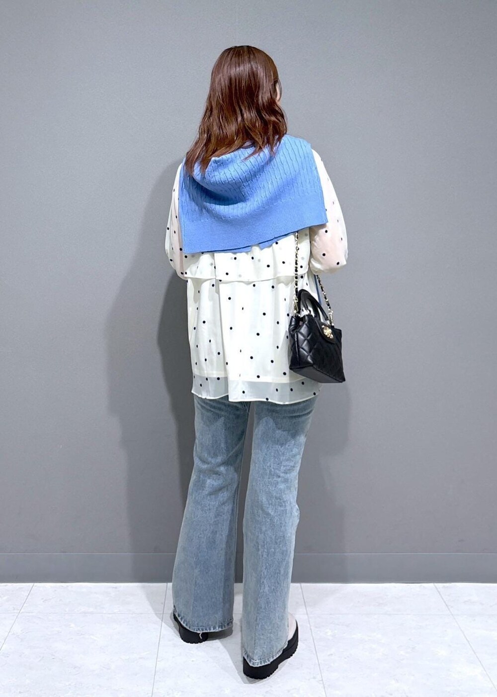 ブルー系のデニムパンツ、ホワイト系のブーツ、ベージュ系のシャツ/ブラウスを着用したレディースの冬コーディネートの3枚目の写真