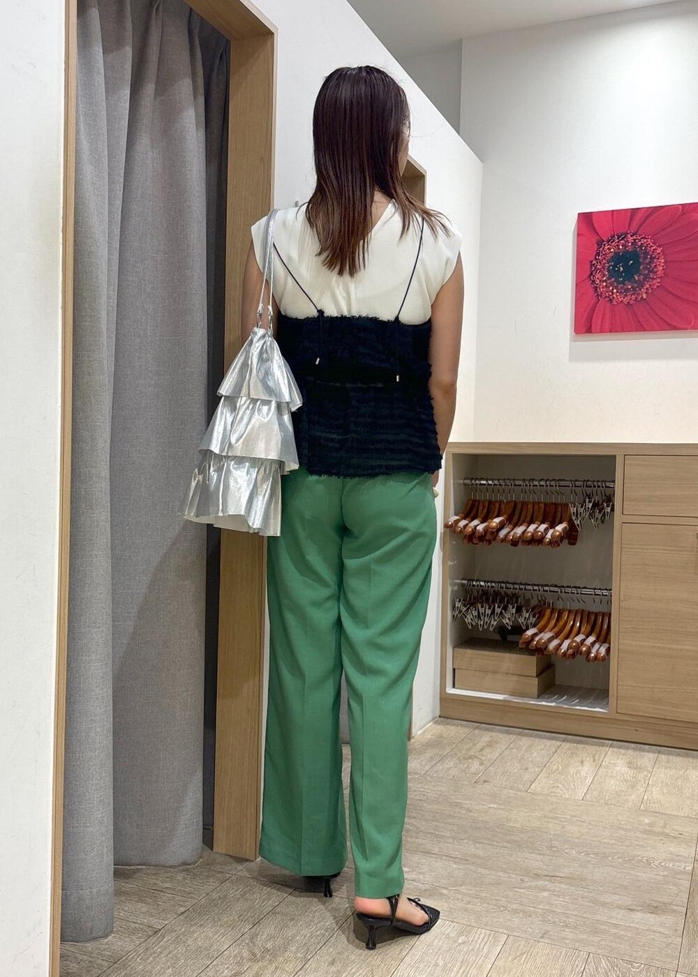 シルバー系のトートバッグ、ブラック系のサンダル、ホワイト系のニット/セーターを着用したレディースの春コーディネートの2枚目の写真