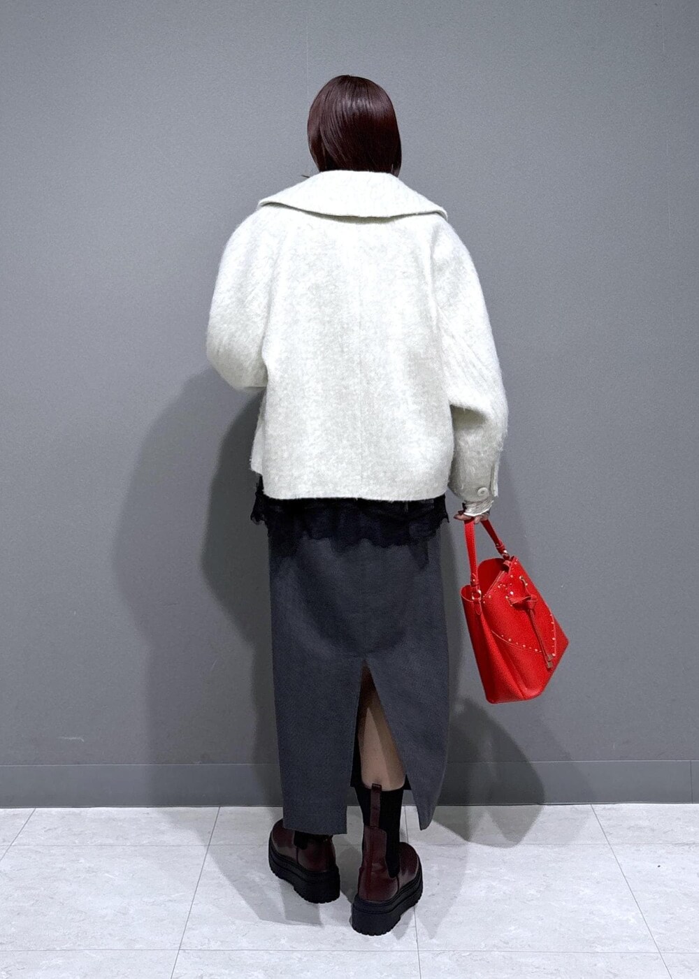 ブラウン系のブーツ、ホワイト系のブルゾン、ホワイト系のTシャツ/カットソーを着用したレディースの冬コーディネートの4枚目の写真