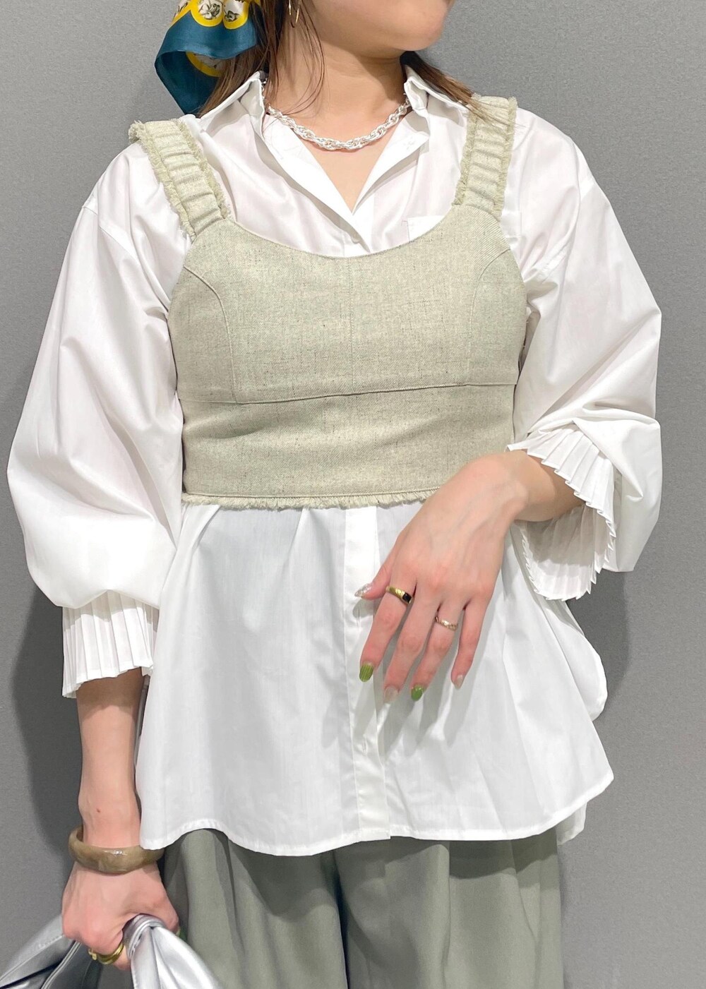 ホワイト系のシャツ/ブラウス、シルバー系のハンドバッグ、ホワイト系のベストを着用したレディースの冬コーディネートの6枚目の写真