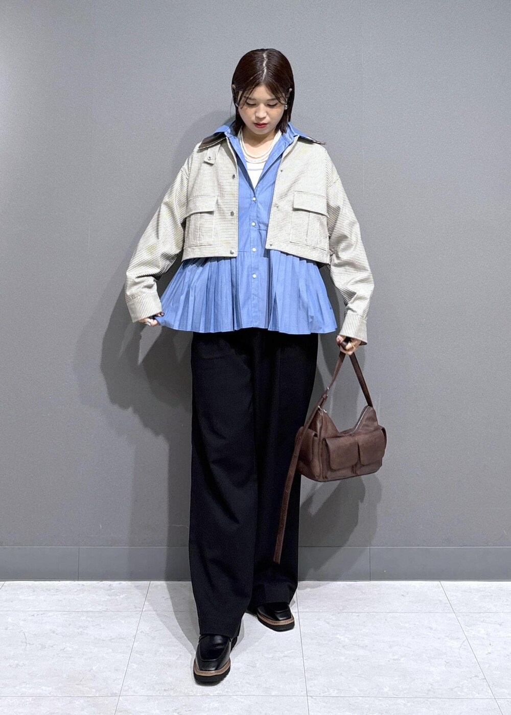 ブラック系のローファー、ブルー系のシャツ/ブラウス、ベージュ系のカバーオールを着用したレディースの秋コーディネートの2枚目の写真