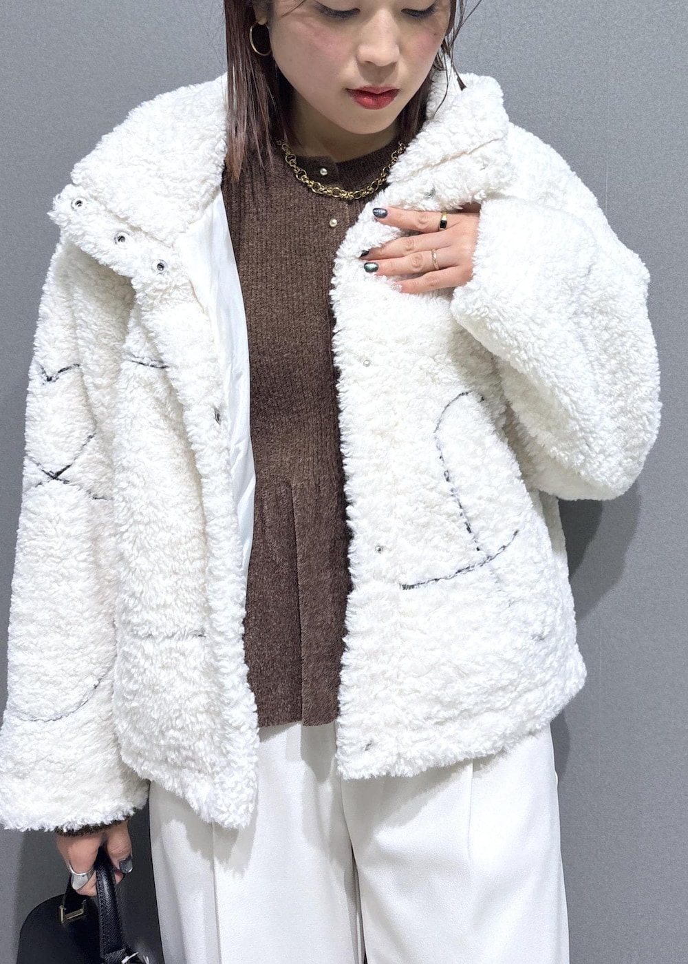 ブラック系のローファー、ホワイト系のブルゾン、ブラック系のハンドバッグを着用したレディースの冬コーディネートの7枚目の写真