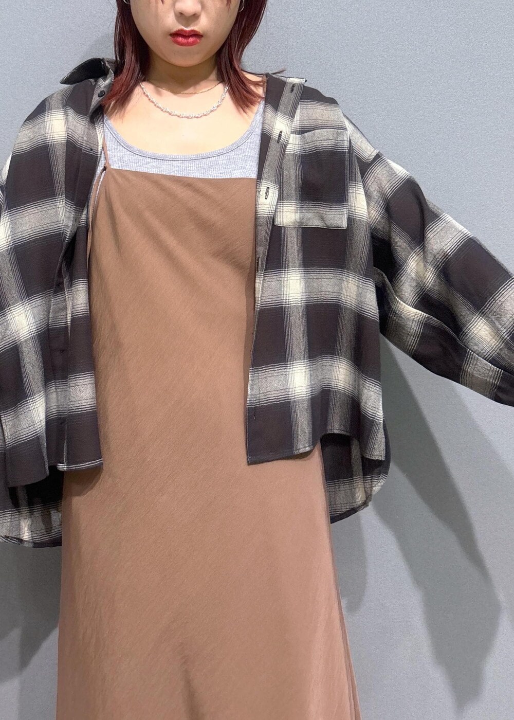 グレー系のタンクトップ、ブルー系のデニムパンツ、ブラウン系のワンピースを着用したレディースの夏コーディネートの4枚目の写真