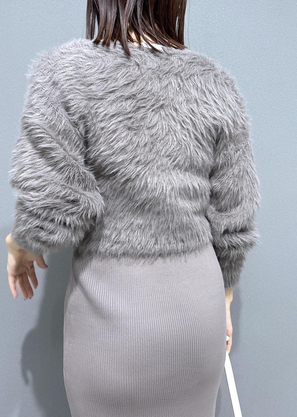 ホワイト系のハンドバッグ、ブラウン系のブーツ、ベージュ系のワンピースを着用したレディースの冬コーディネートの8枚目の写真