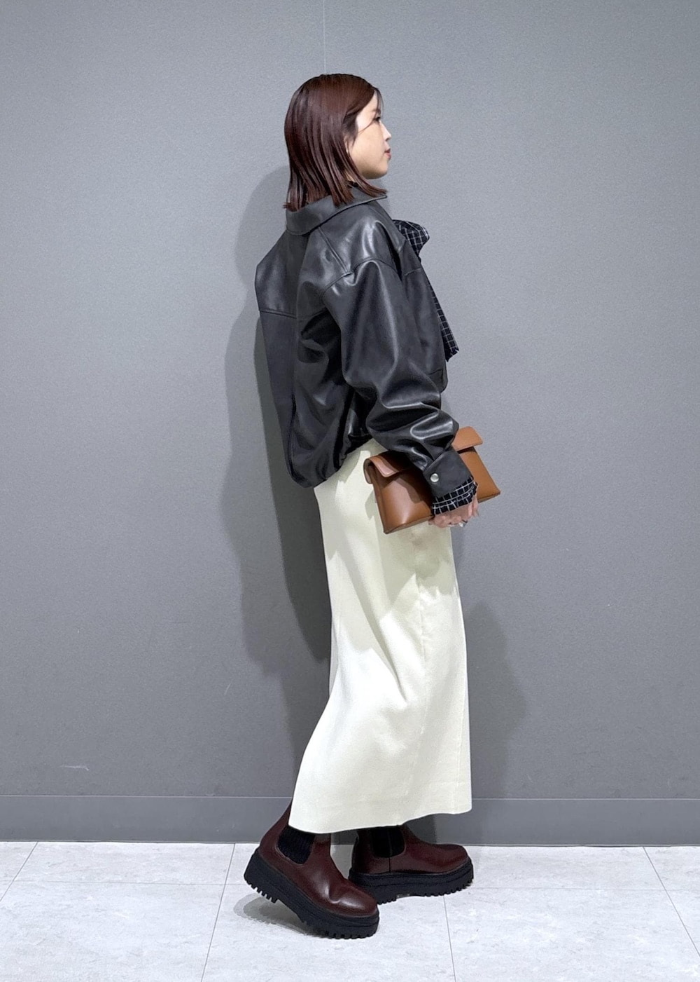 ブラウン系のブーツ、ブラック系のシャツ/ブラウス、ブラック系のブルゾンを着用したレディースの冬コーディネートの2枚目の写真