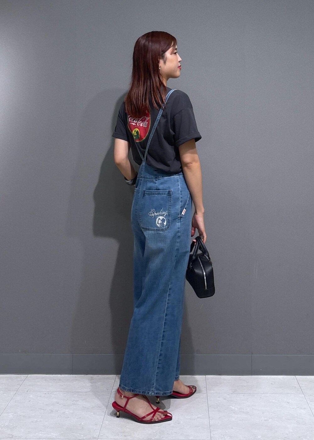 レッド系のサンダル、ブラック系のショルダーバッグ、グレー系のTシャツ/カットソーを着用したレディースの夏コーディネートの2枚目の写真