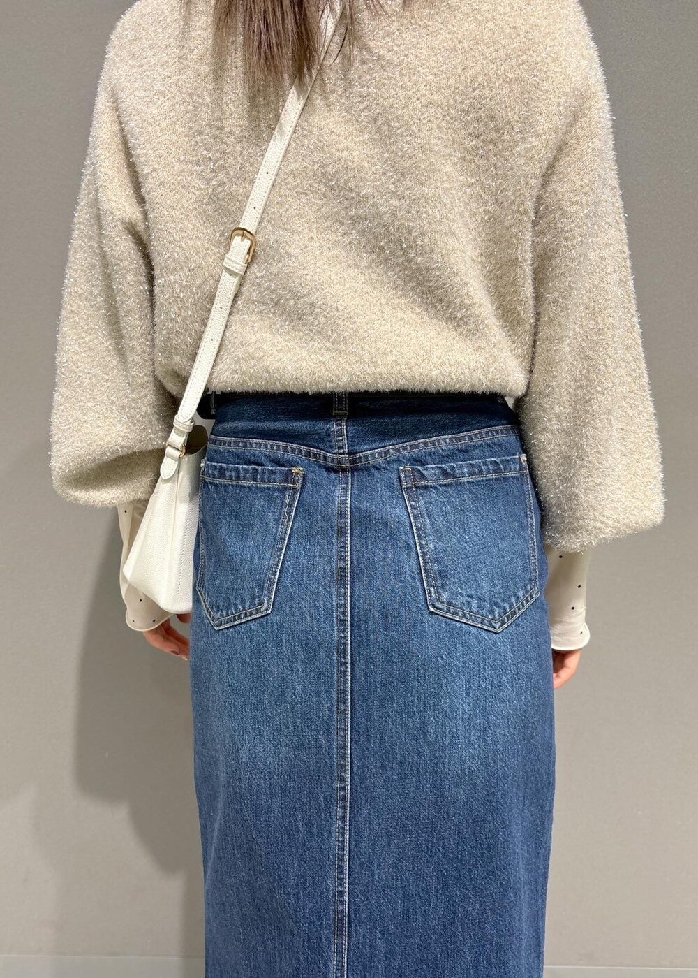 ホワイト系のショルダーバッグ、ブラック系のブーツ、ホワイト系のTシャツ/カットソーを着用したレディースの冬コーディネートの7枚目の写真