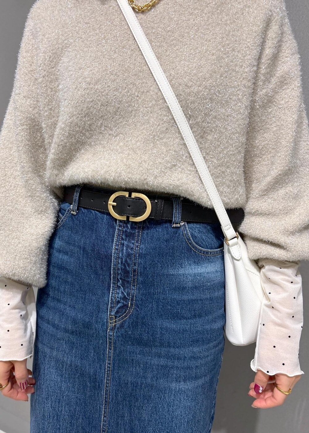 ホワイト系のショルダーバッグ、ブラック系のブーツ、ホワイト系のTシャツ/カットソーを着用したレディースの冬コーディネートの6枚目の写真