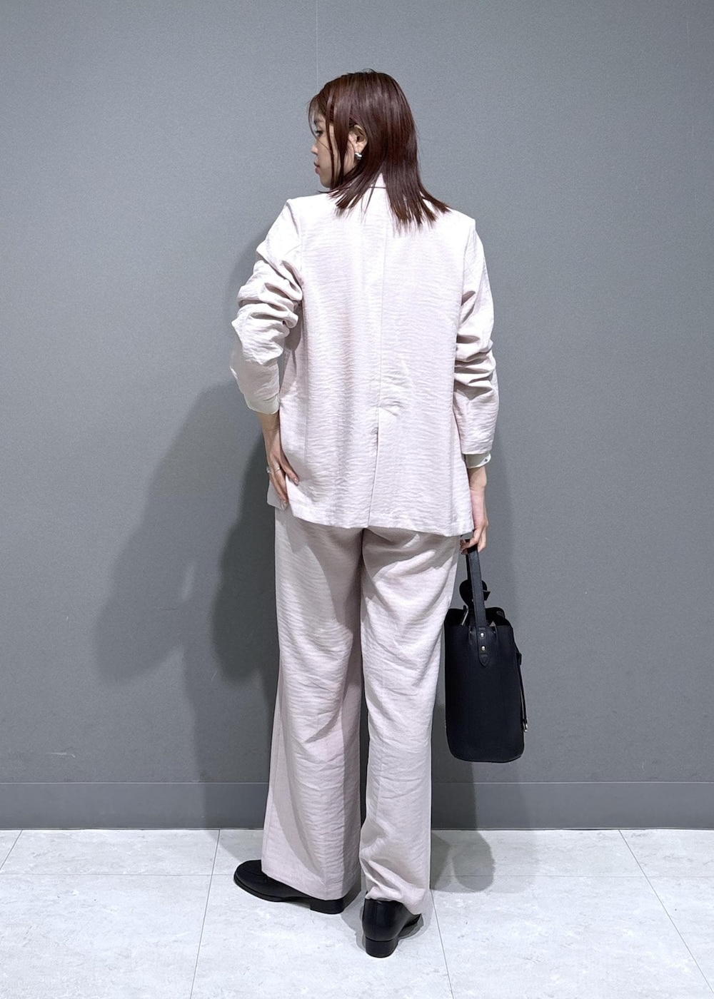 ブラック系のショルダーバッグ、ブラック系のローファー、ホワイト系のカーディガン/ボレロを着用したレディースの春コーディネートの4枚目の写真