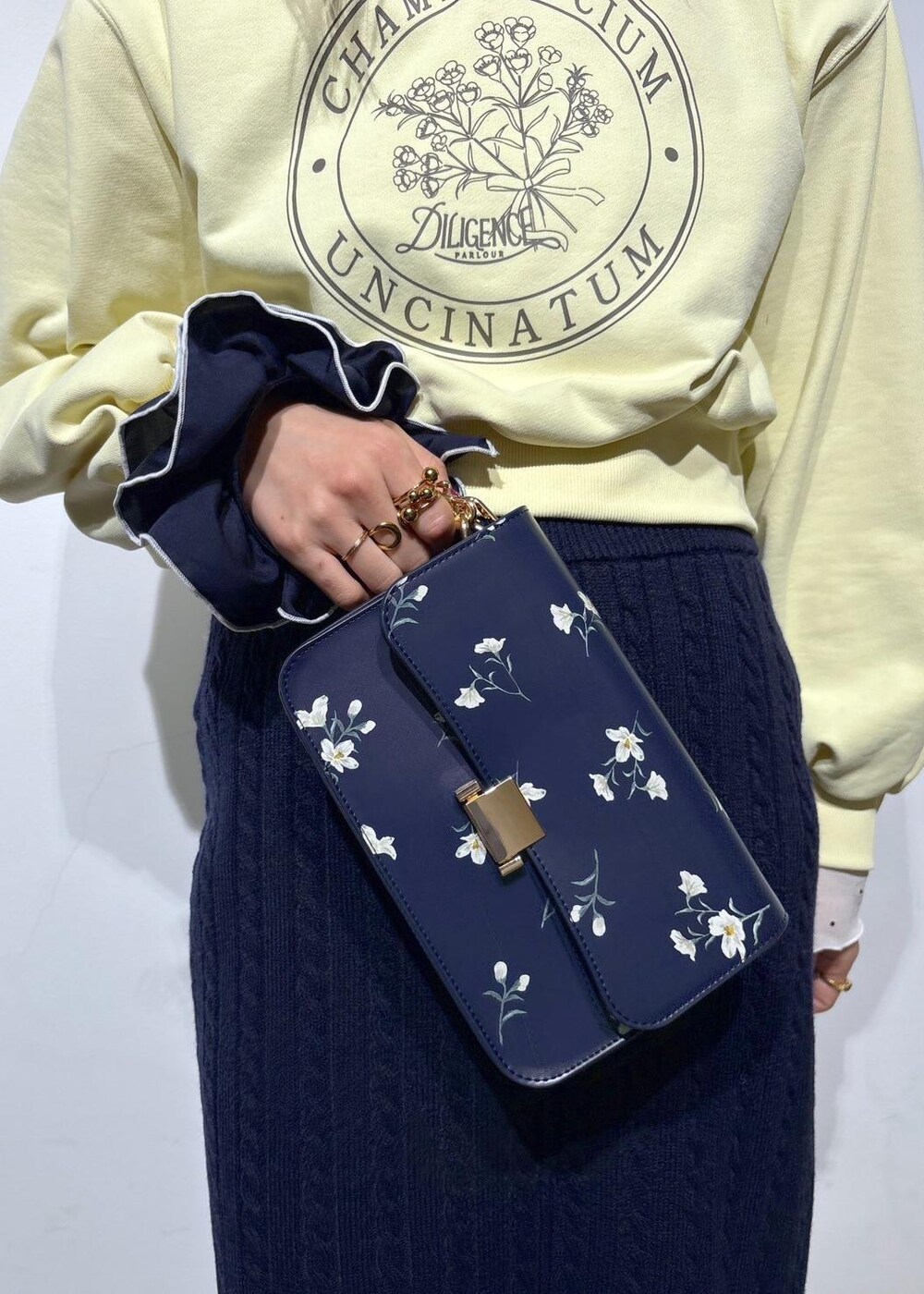 ホワイト系のブーツ、ブルー系のスカート、ブルー系のハンドバッグを着用したレディースの冬コーディネートの6枚目の写真