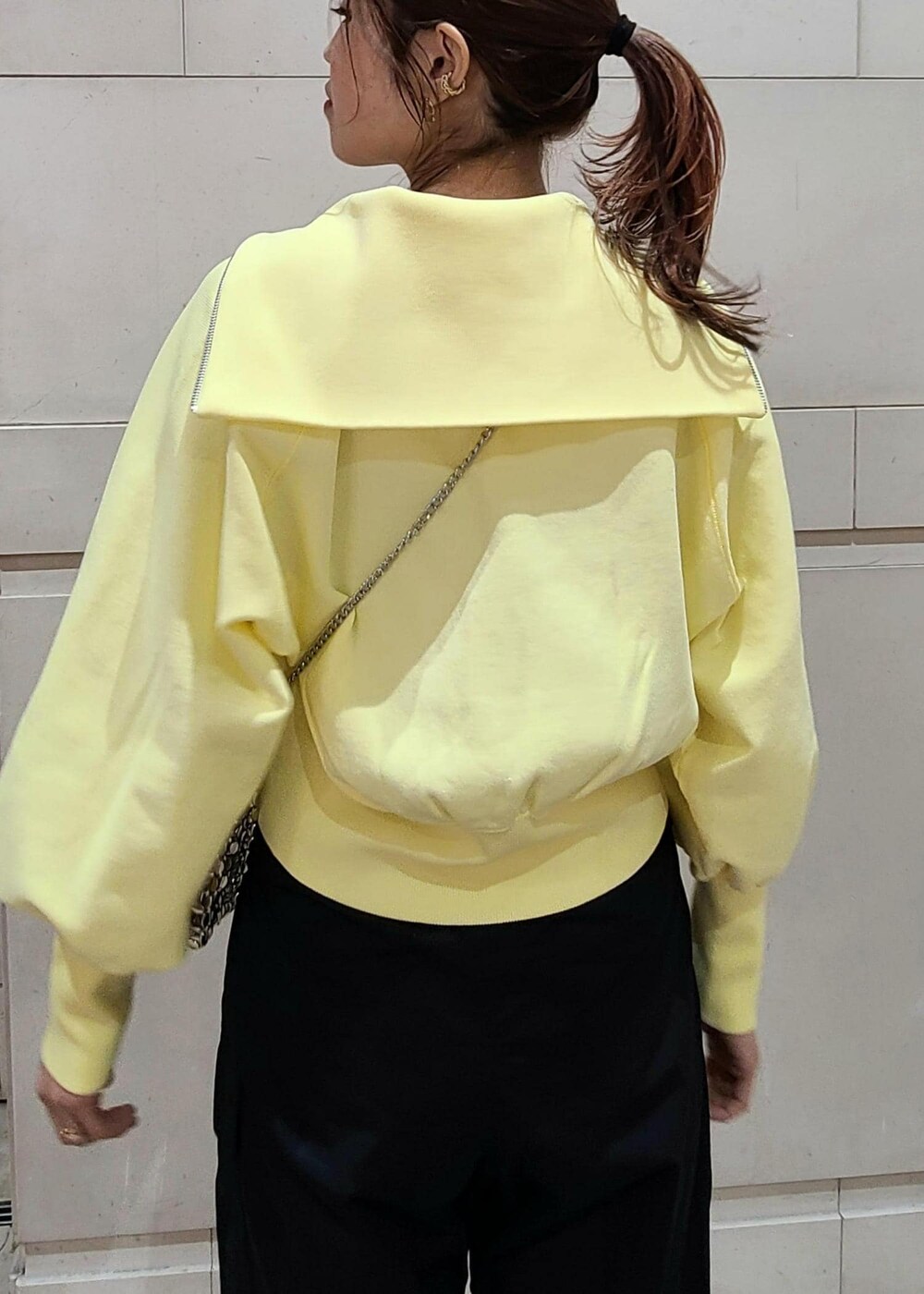 イエロー系のカーディガン/ボレロ、シルバー系のショルダーバッグ、ブラック系のカーゴパンツを着用したレディースの冬コーディネートの4枚目の写真