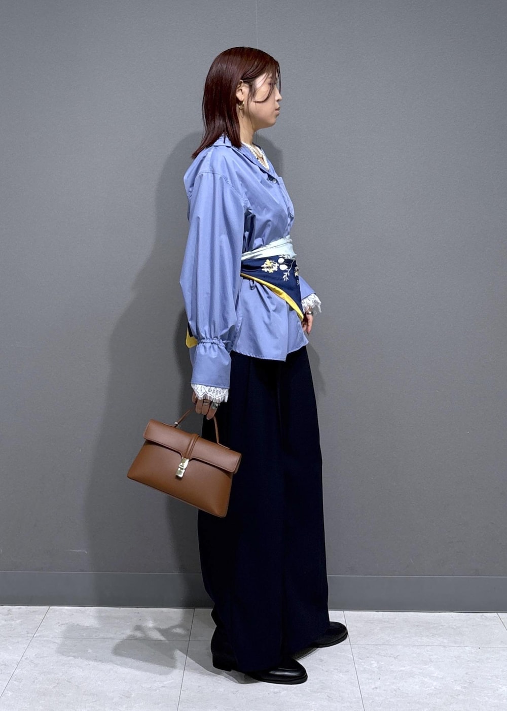 ブルー系のその他パンツ、ブラック系のローファー、イエロー系のショルダーバッグを着用したレディースの冬コーディネートの3枚目の写真