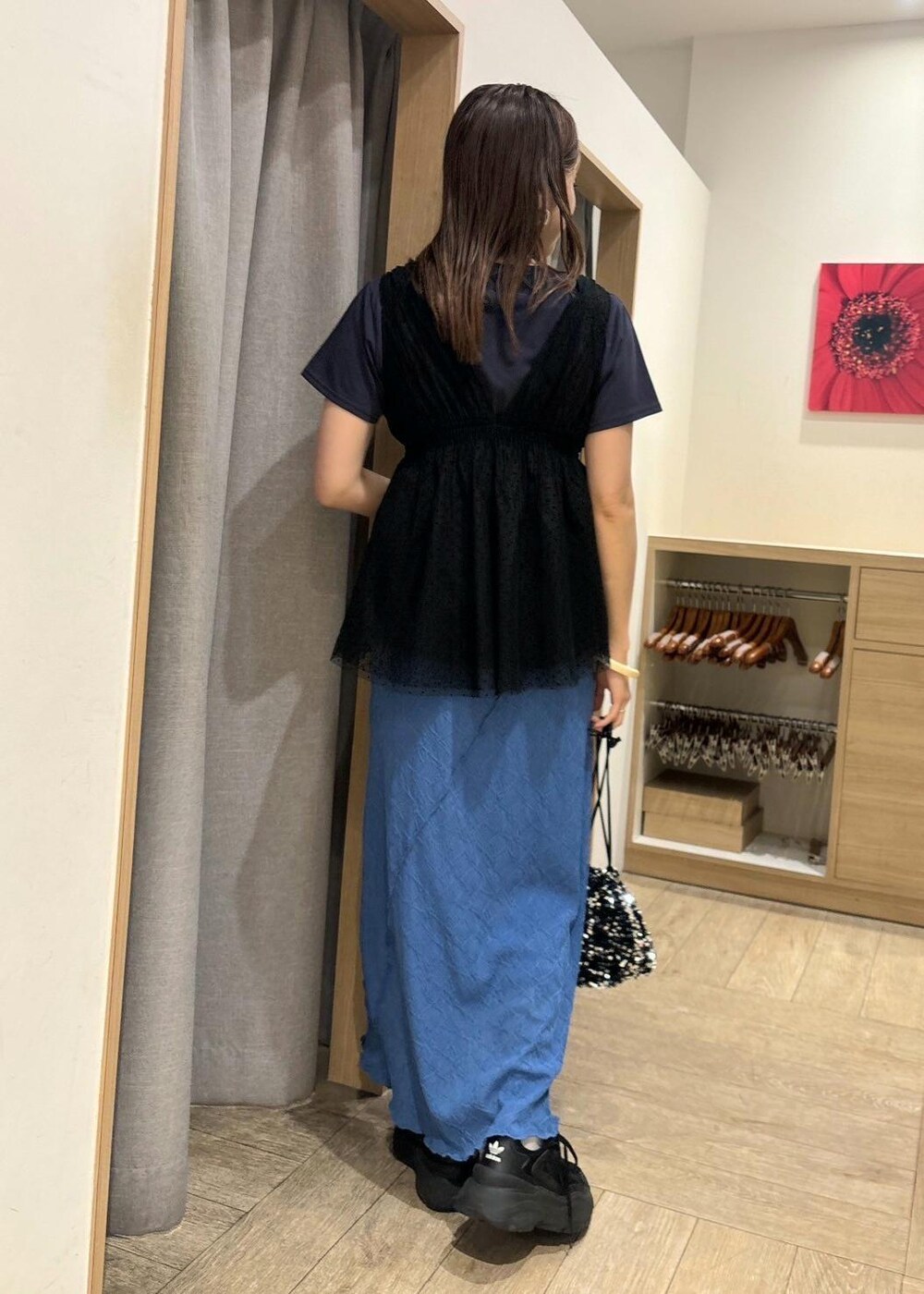 シルバー系のハンドバッグ、ブルー系のワンピース、ブラック系のシャツ/ブラウスを着用したレディースの春コーディネートの2枚目の写真