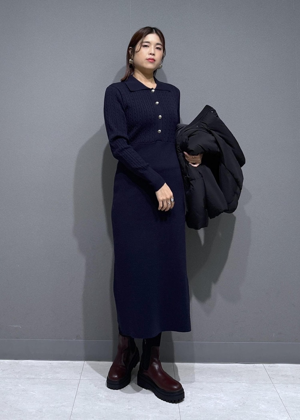 ブラウン系のショルダーバッグ、ブラウン系のブーツ、ブルー系のワンピースを着用したレディースの冬コーディネートの5枚目の写真