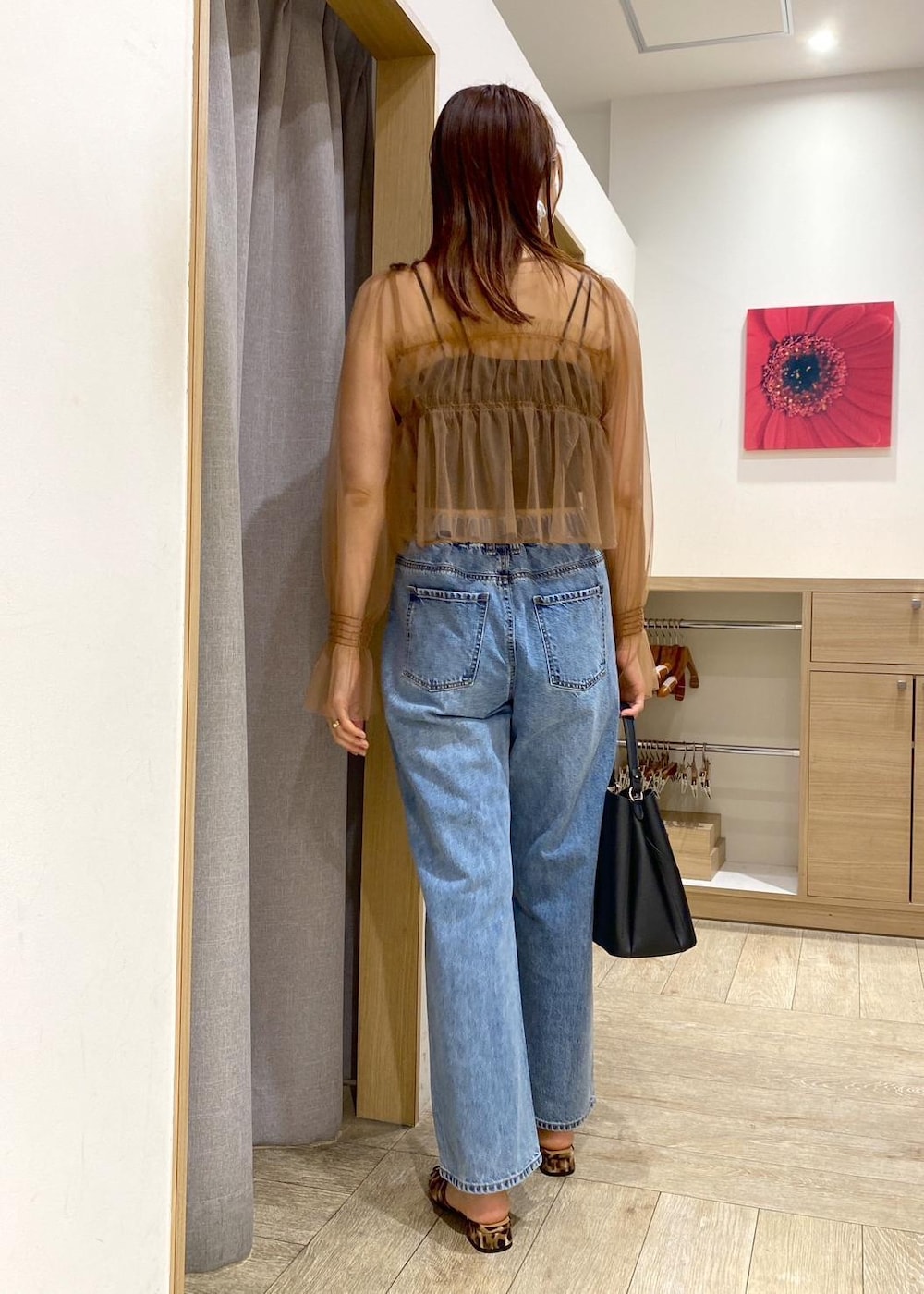 ブラック系のハンドバッグ、ブルー系のデニムパンツ、その他のサンダルを着用したレディースの春コーディネートの2枚目の写真