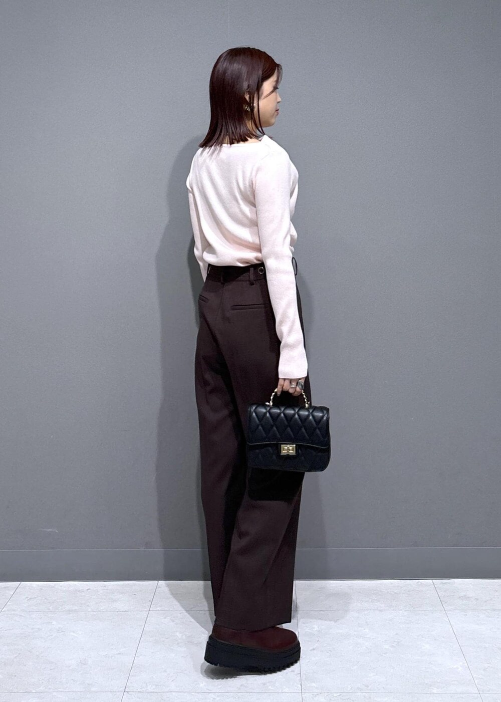 ブラウン系のスラックス、ブラウン系のブーツ、グレー系のその他アウターを着用したレディースの冬コーディネートの5枚目の写真