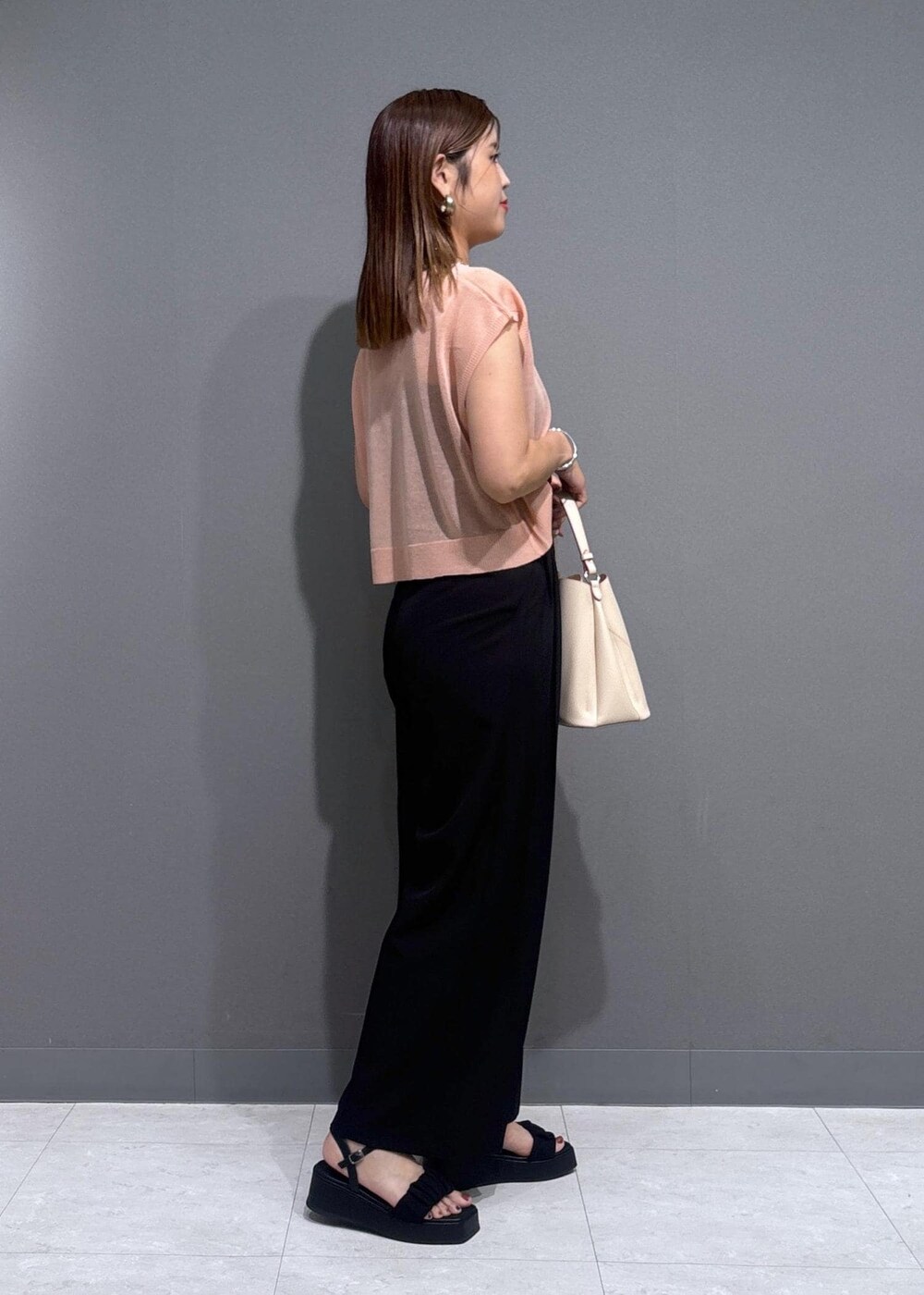 ベージュ系のショルダーバッグ、ブラック系のサンダル、ブラック系のキャミソールを着用したレディースの夏コーディネートの2枚目の写真