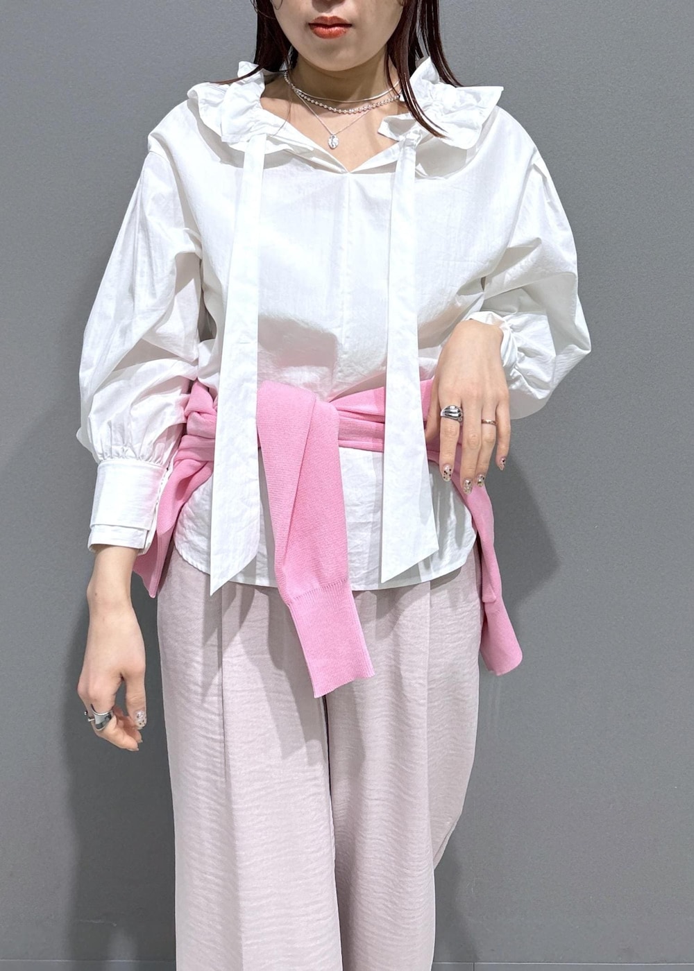 ブラック系のショルダーバッグ、ブラック系のローファー、ピンク系のカーディガン/ボレロを着用したレディースの春コーディネートの5枚目の写真